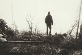 black and white photo of the back of a man as he stares into distance