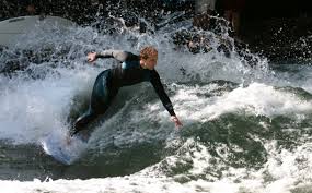man in black wetsuit riding a wave
