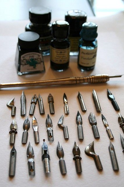 pen nibs and bottles of ink on a desk