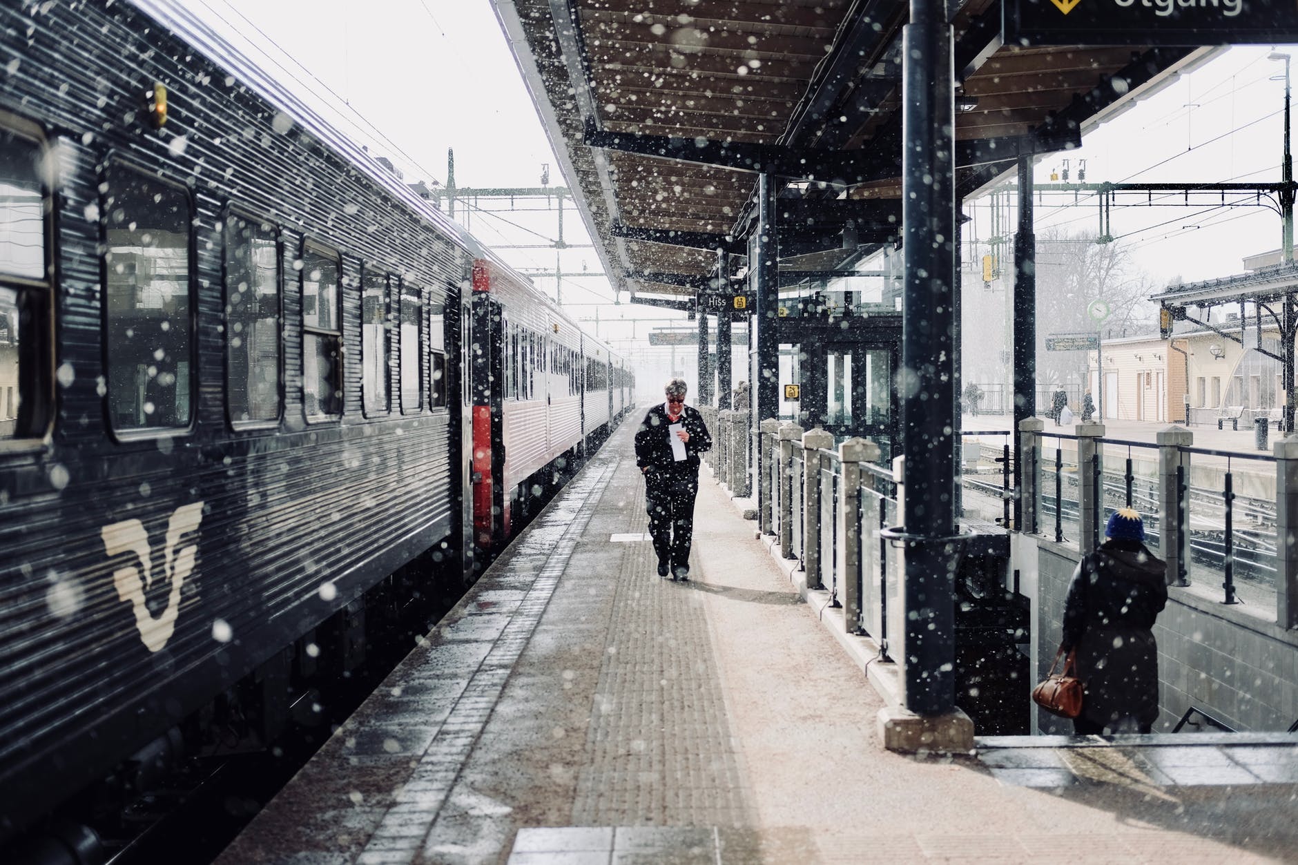 man walks beside train