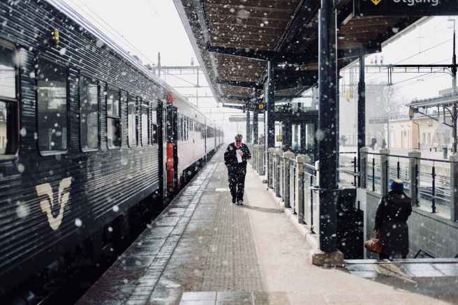 man walks beside train