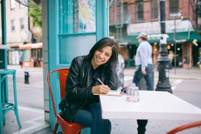 woman in black leather jacket sitting on red chair