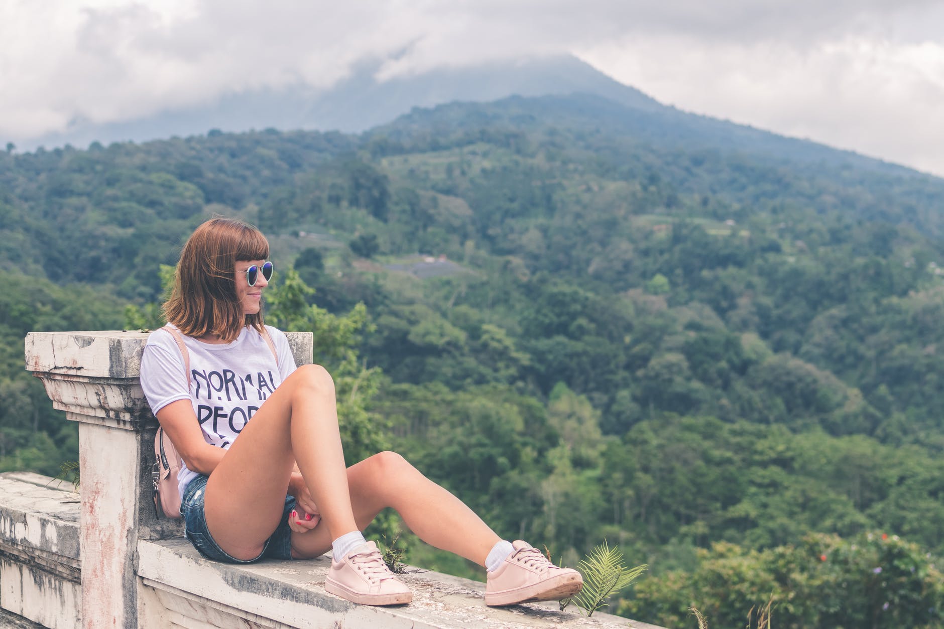 woman in white shirt and blue denim short shorts sitting
